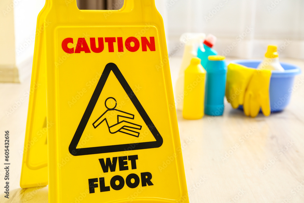 Caution sign on wet floor in room, closeup