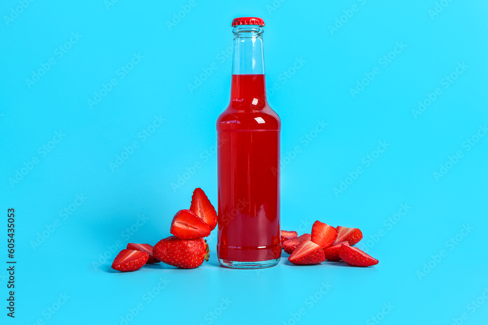 Bottle of fresh soda and strawberry on blue background