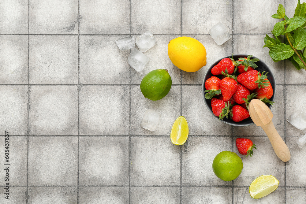 Bowl with ripe strawberry, lime, lemon and mint on tile background