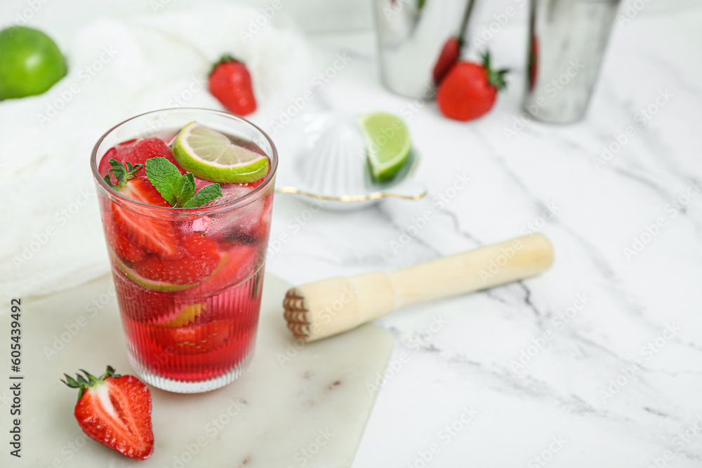 Glass of delicious strawberry mojito on light background, closeup