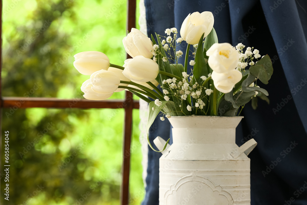 Vase with blooming tulip flowers near window