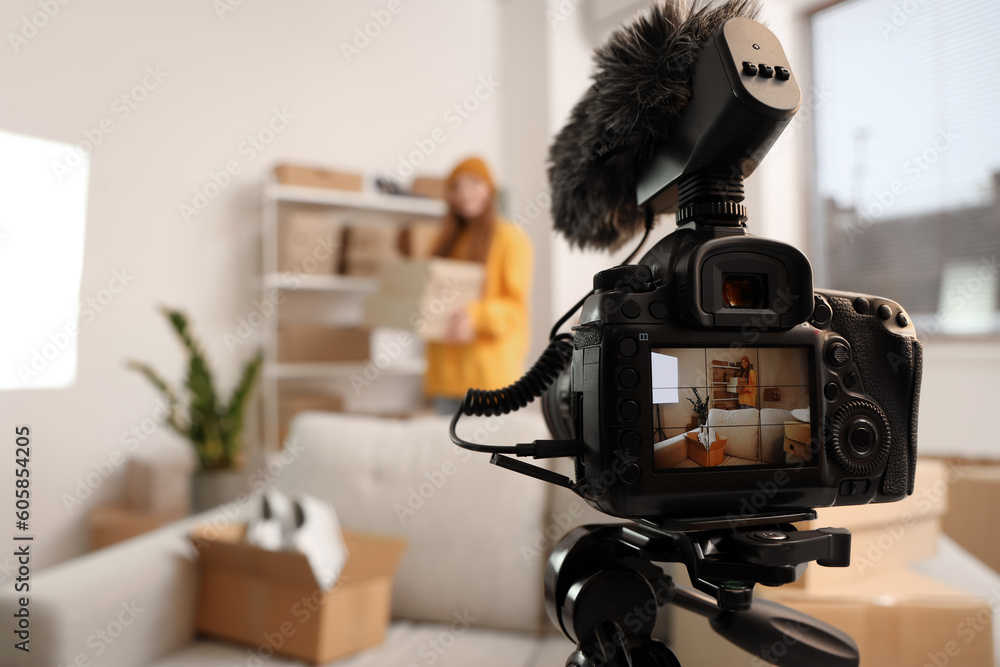 Female seller with shoe boxes on camera screen at home, closeup