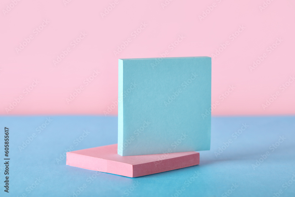 Sticky notes on blue table near pink wall