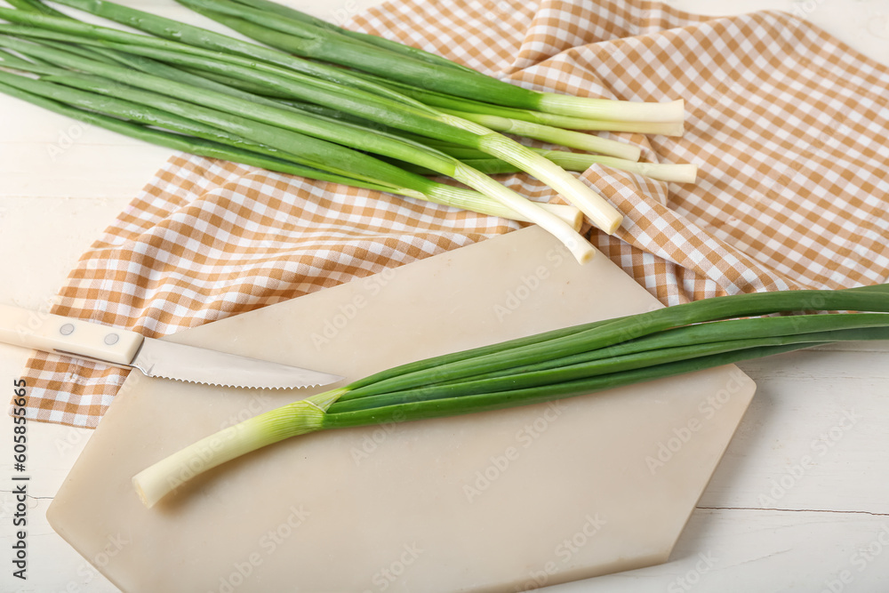 Board with fresh green onion on table