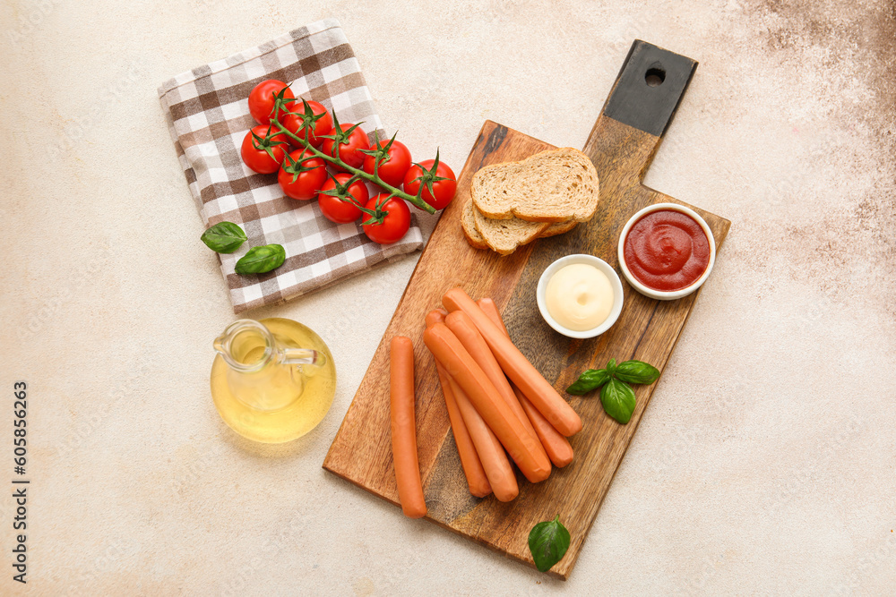 Board of tasty sausages with basil and tomatoes on grey background