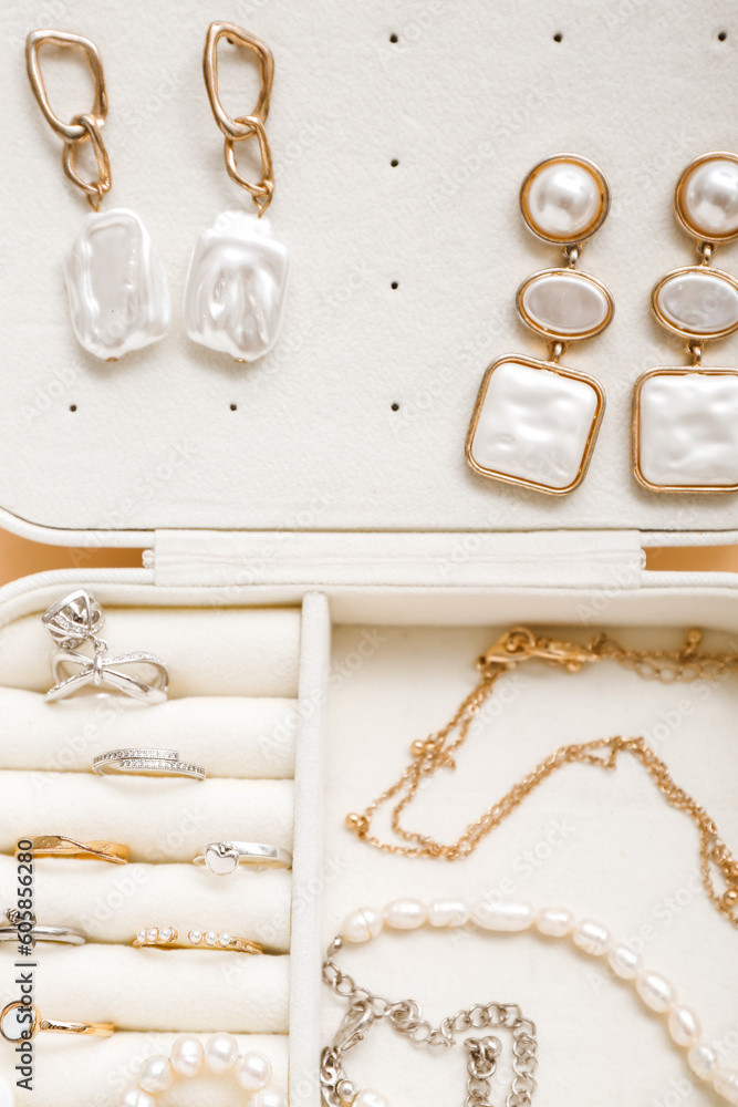 Organizer with stylish jewelry on pale orange background