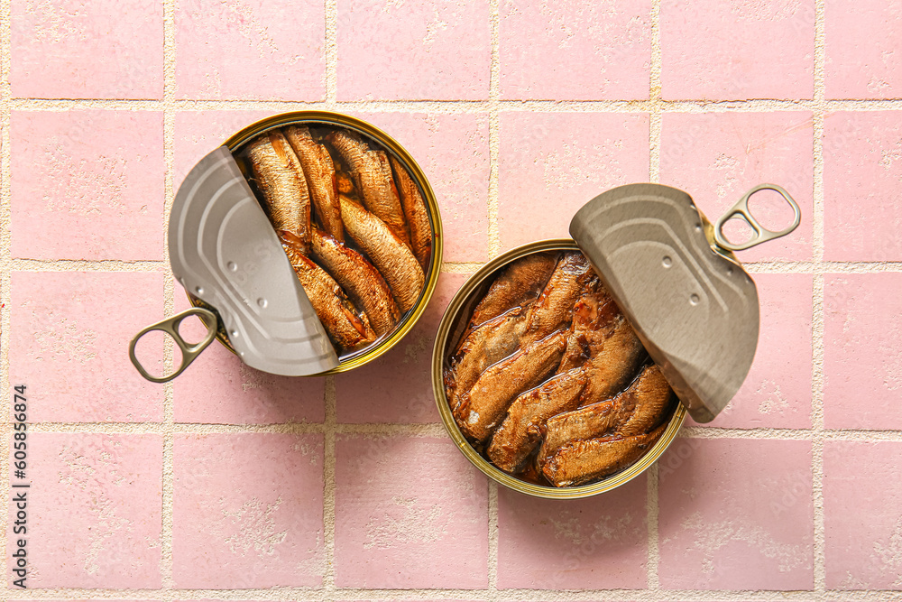 Canned smoked sprats on pink tile background