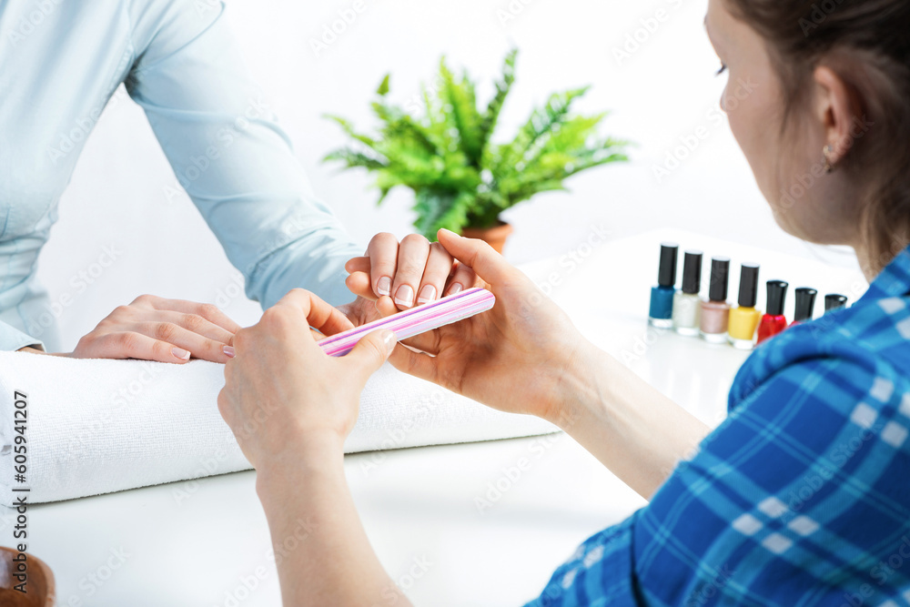 Manicurist using nail file and create nails shape