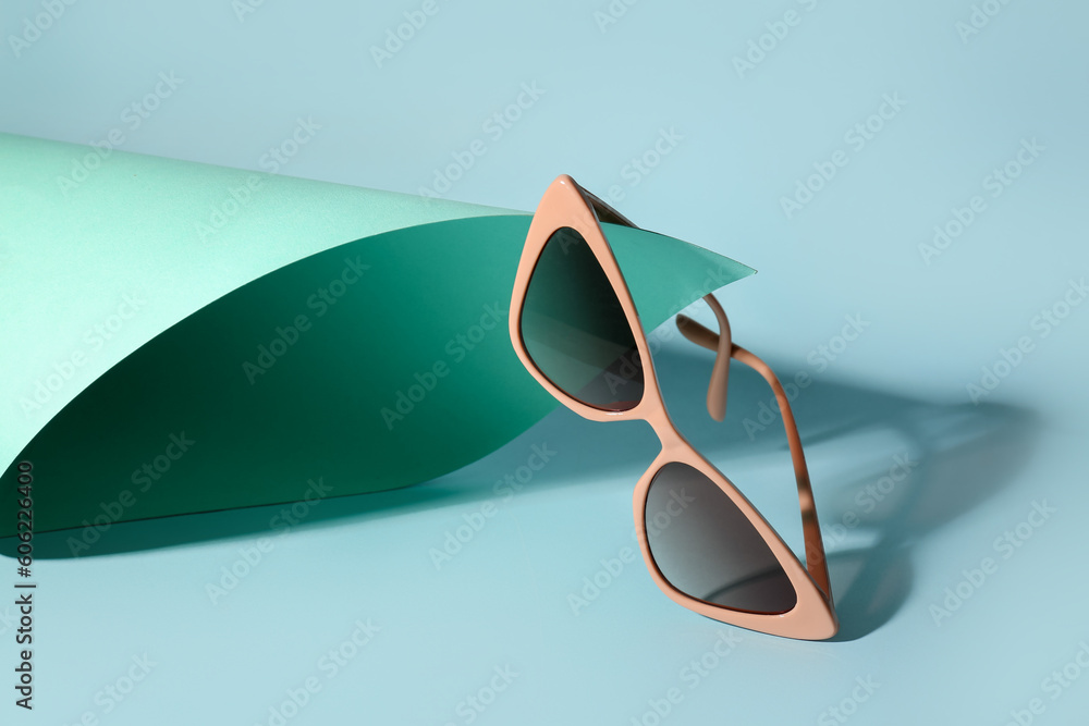 Stylish sunglasses on color background