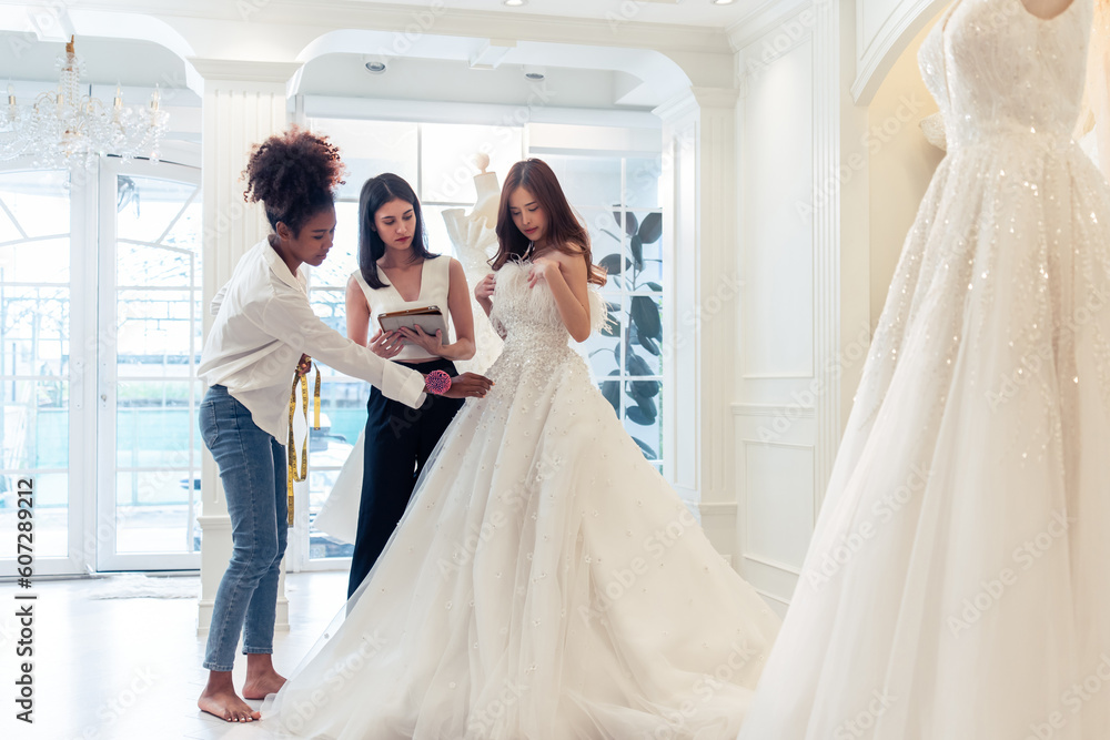 Beautiful bride discussing details with the wedding planner in studio. 