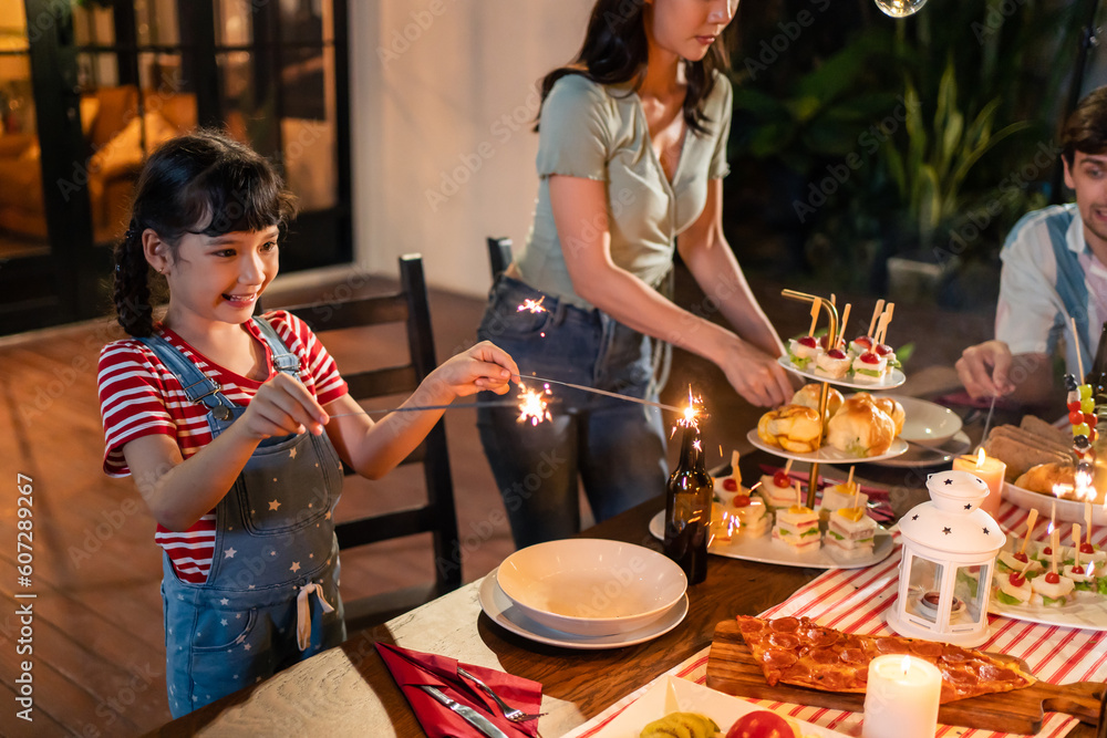 Attractive young kid child playing sparklerwhile having party outdoor. 