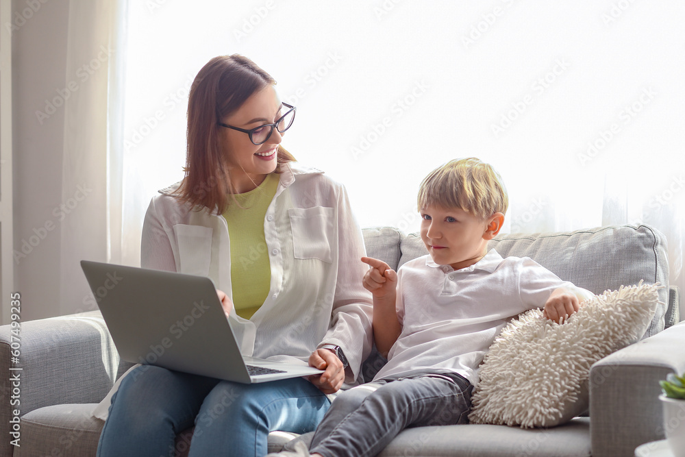 Nanny with little boy watching cartoons at home