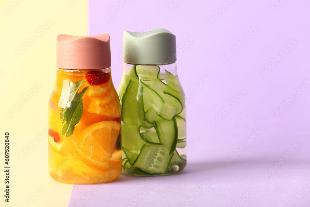 Sports bottles of infused water with different sliced fruits on colorful background