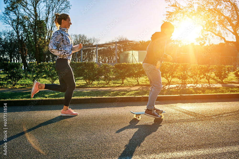 Happy family outdoors, mother and son go in sports, Boy rides skateboard, mom runs on sunny day. Sil