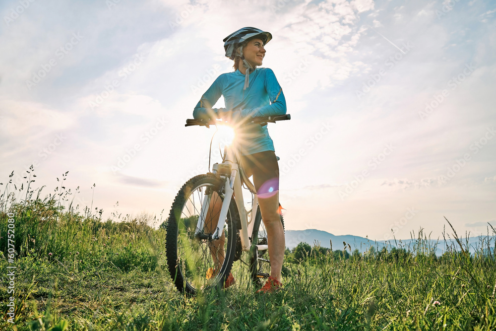 Cyclist Woman riding bike in helmets go in sports outdoors on sunny day a mountain in the forest. Si