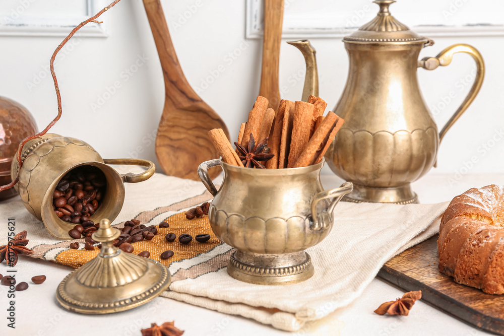 Composition with vintage tableware, cinnamon sticks and coffee beans on light table