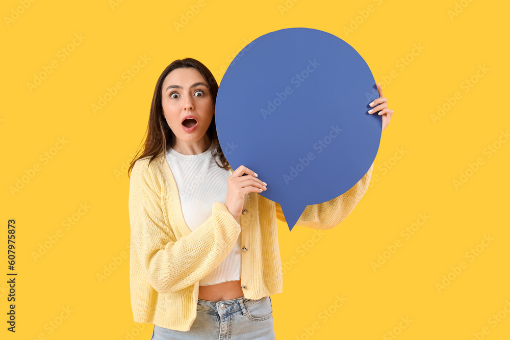 Shocked young woman with blank speech bubble on yellow background