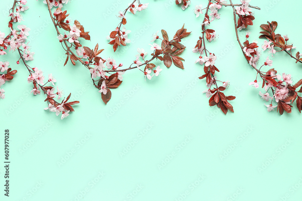 Blooming tree branches with pink flowers on turquoise background