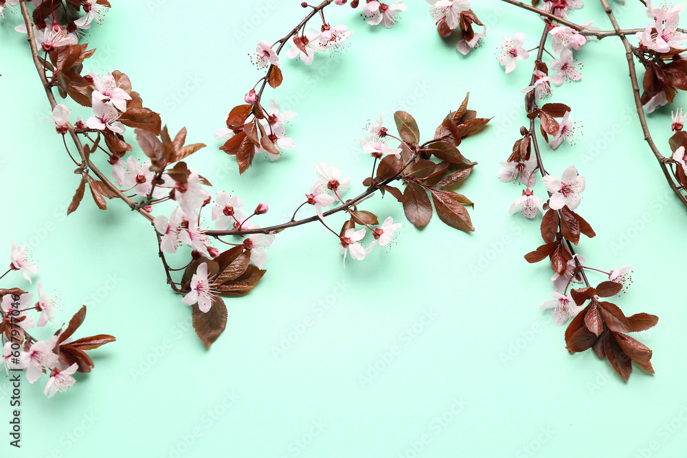 Blooming tree branches with pink flowers on turquoise background