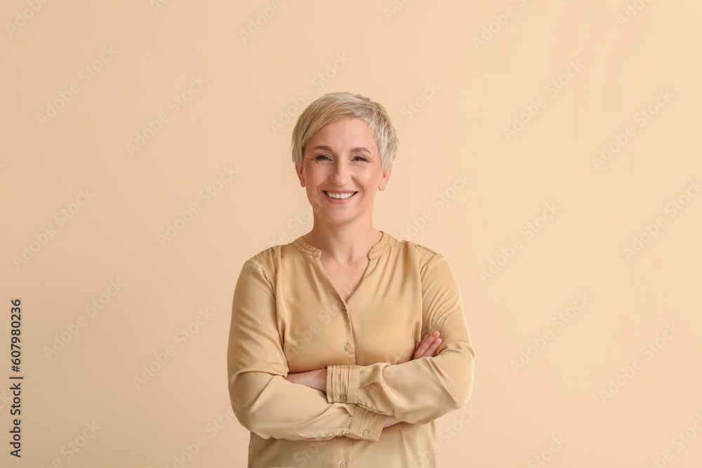 Mature blonde woman on beige background