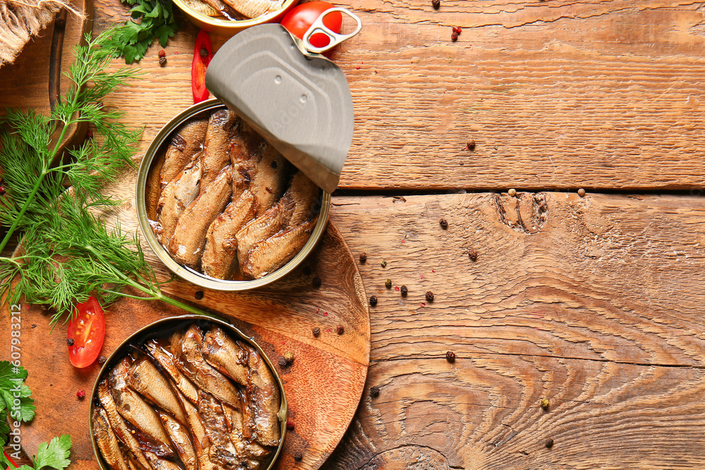 Plate of canned smoked sprats with dill and peppercorn on wooden background