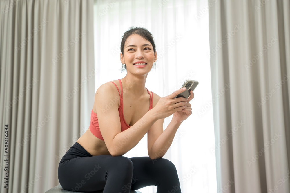 Beautiful woman exercising fitness at home and talking to mobile phone, Home interior, Fitness mat.