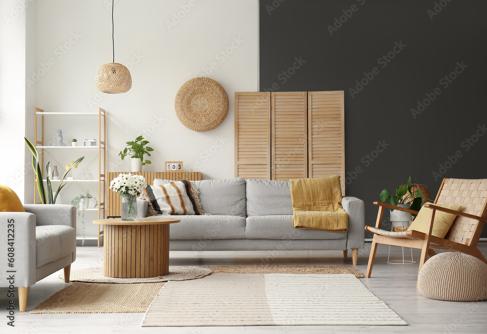 Interior of light living room with grey sofas, wooden armchair and coffee table