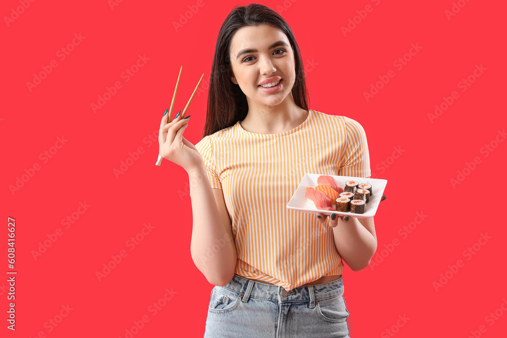 Young woman with sushi rolls and chopsticks on red background