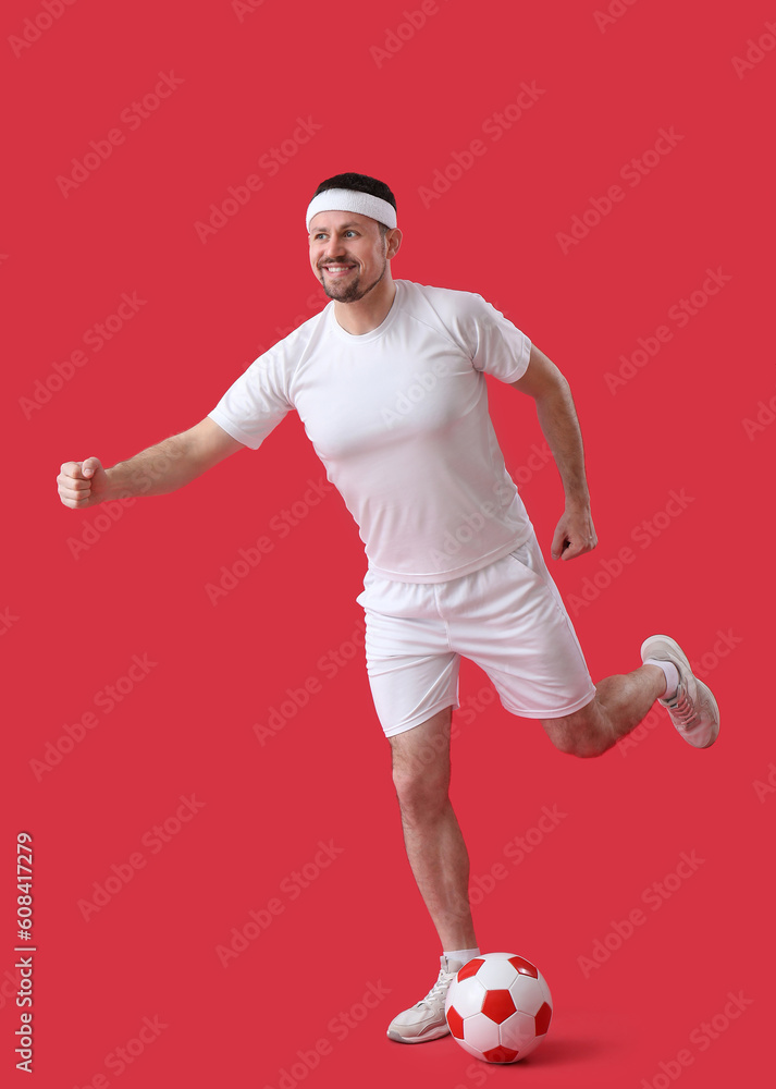 Man playing soccer on red background