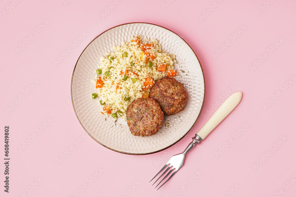 Cutlets with bulgur, boiled vegetables and fork on pink background