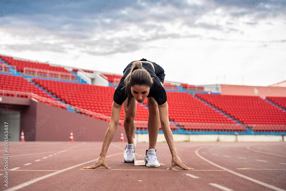 Asian young sportswoman sprint on a running track outdoors on stadium. 