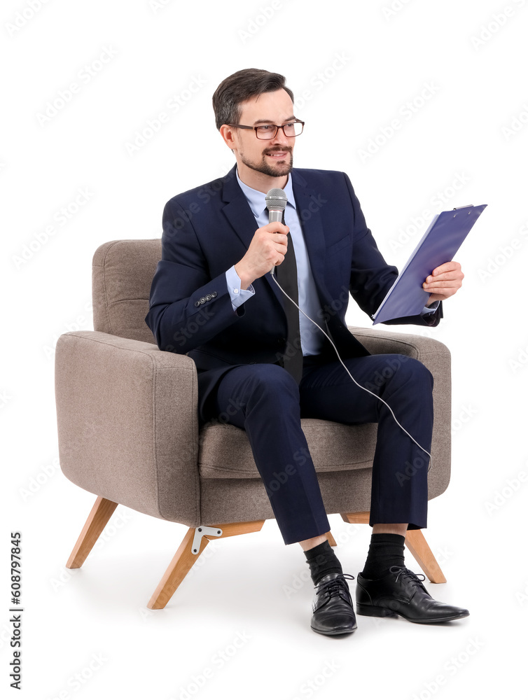 Male journalist with microphone and clipboard in armchair on white background