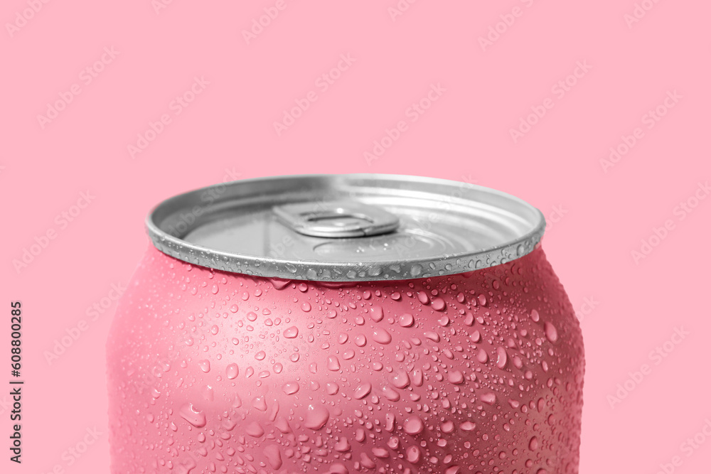 Can of fresh soda with water drops on pink background, closeup