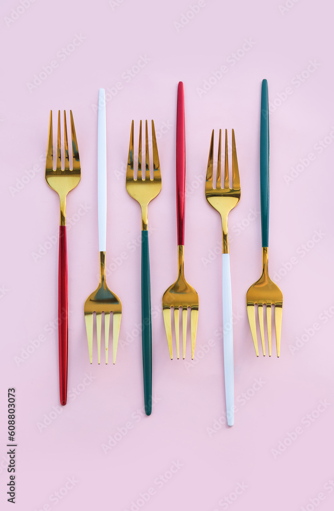 Golden forks on pink background