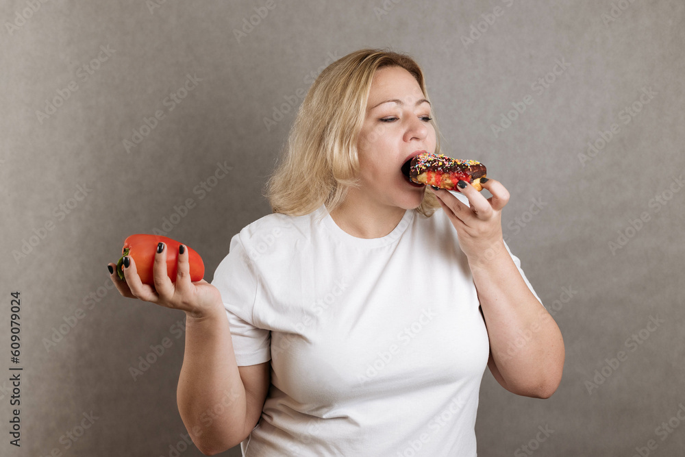 Close-up portrait of a plus-size blonde, holding a pepper in one hand and a chick in the other. Eati