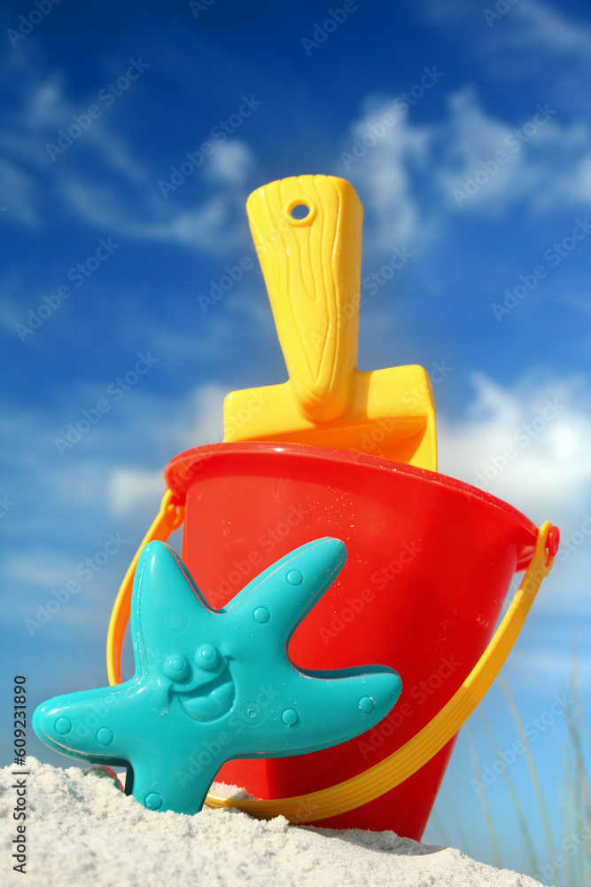 Bucket and spade on tropical beach with blue sky