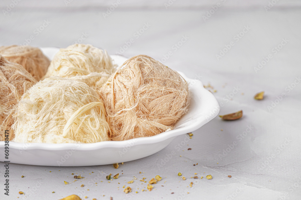 Plate with tasty Turkish Pismaniye on light background, closeup