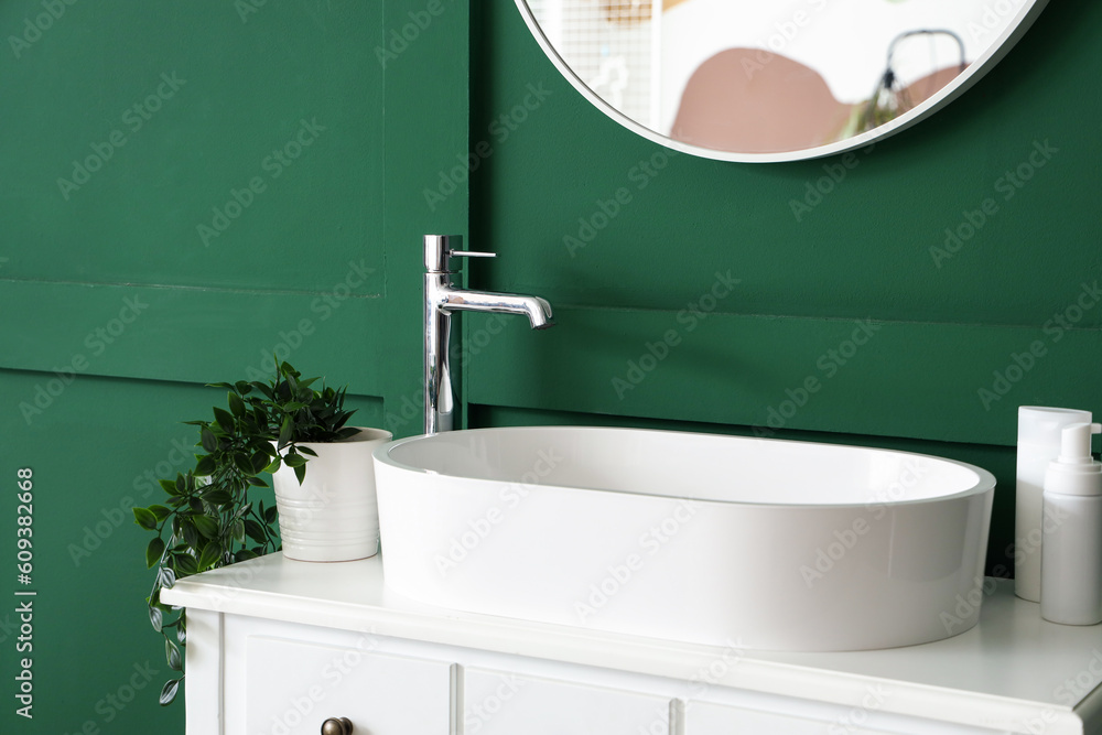 Dressing table with sink near green wall in bathroom