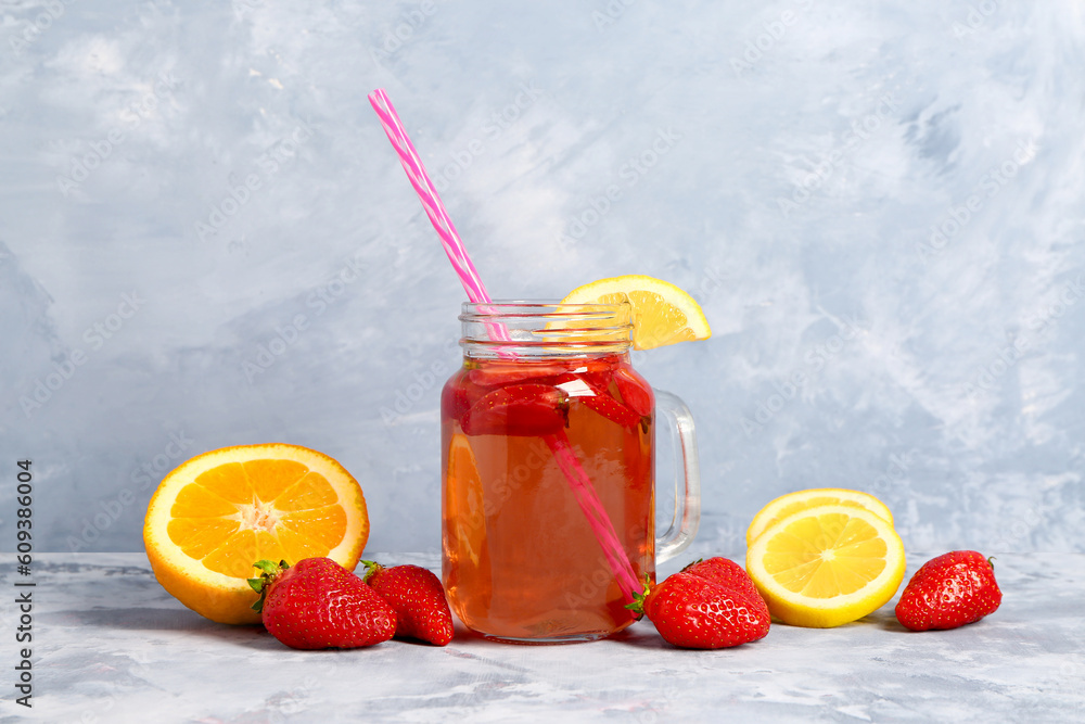 Mason jar of tasty strawberry juice on blue table