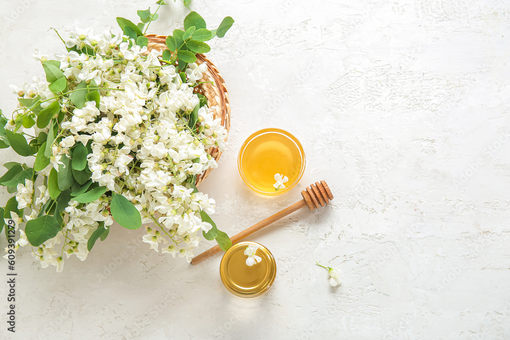 Basket with acacia flowers and sweet honey on light background