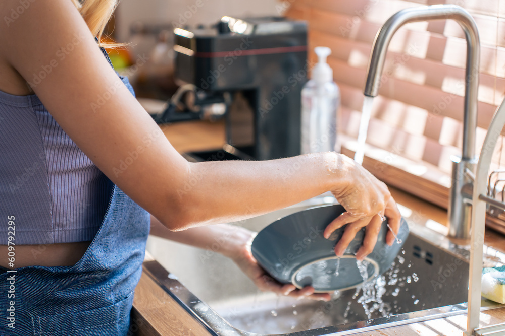 Close up hands of housewife washing dishes in at the kitchen sink. 