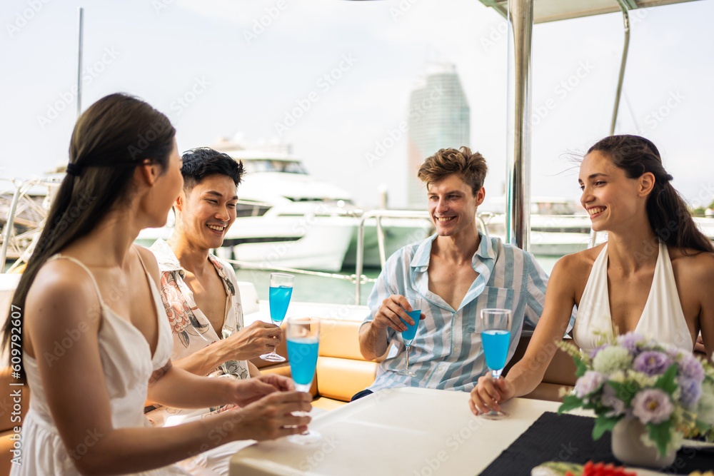 Group of diverse friends drink champagne while having a party in yacht. 