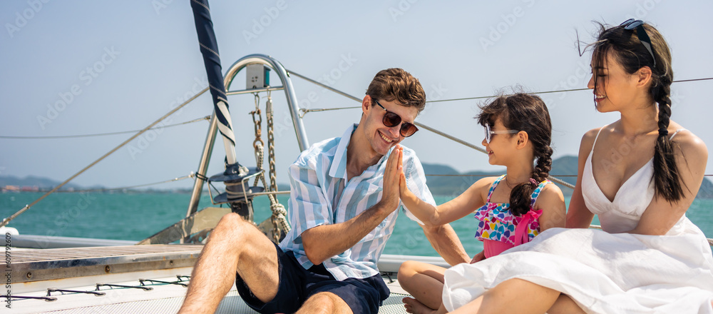 Caucasian happy family sitting on deck of yacht while yachting outdoor. 