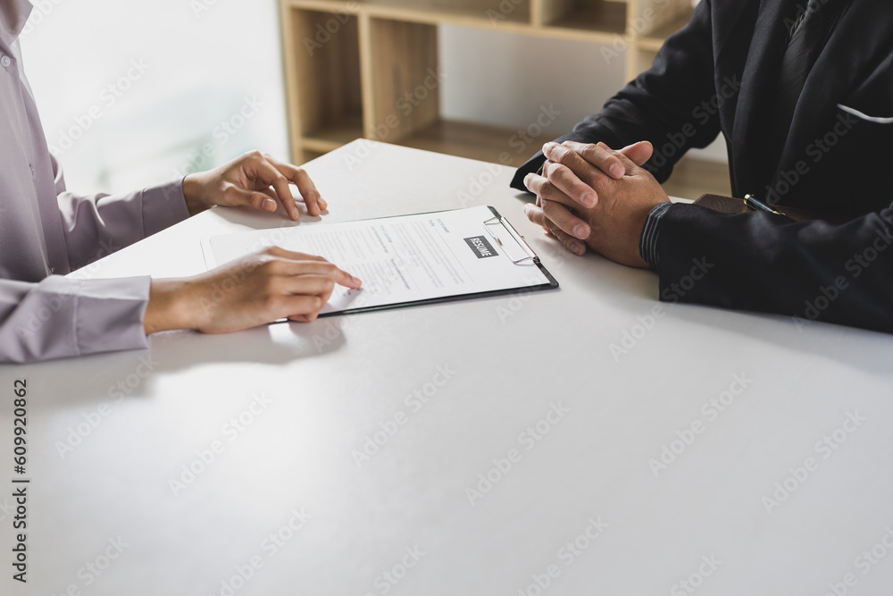 Woman submits an application to the personnel committee. The manager reads the resume and discusses 