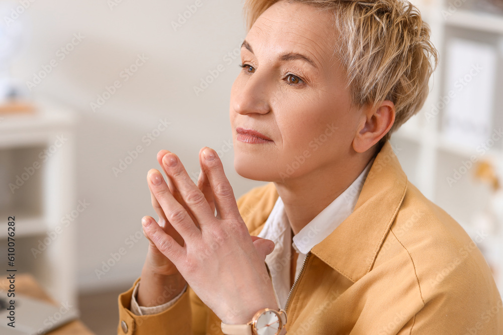 Thoughtful mature woman in office, closeup