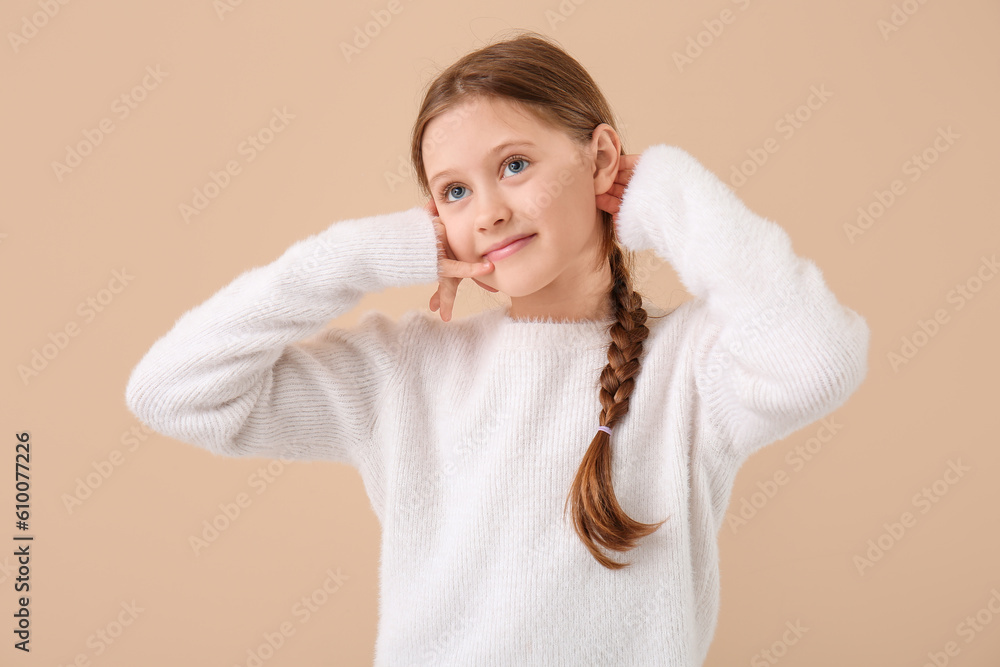 Little girl showing  call me  gesture on beige background