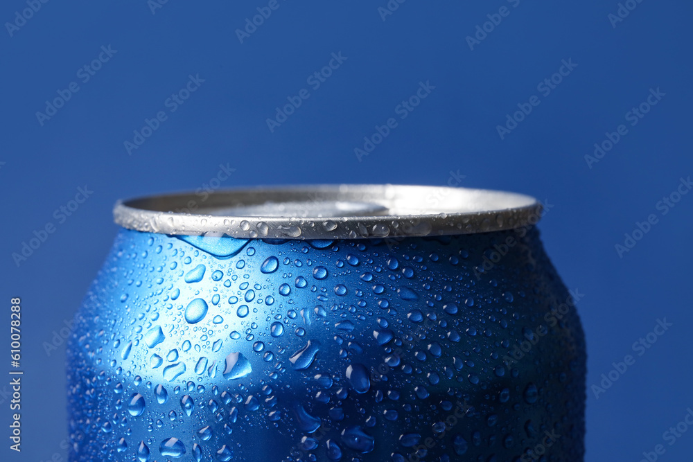 Can of fresh soda with water drops on blue background, closeup