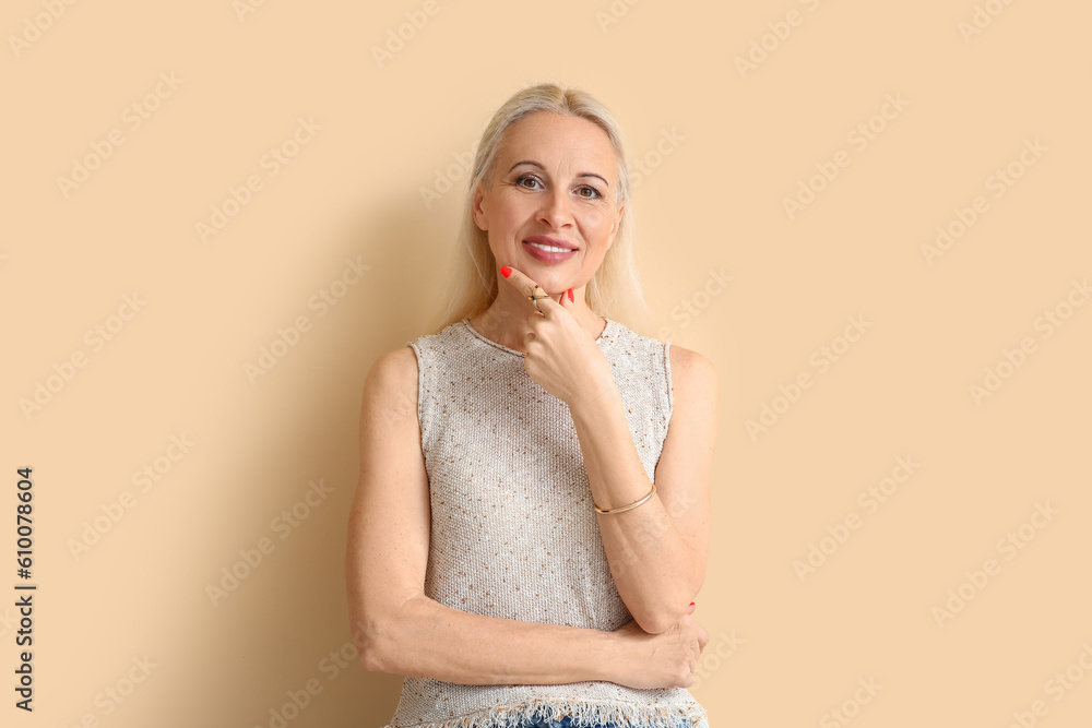 Mature blonde woman on beige background