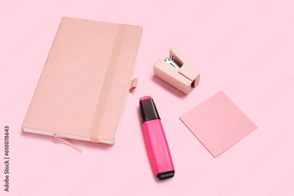 Sticky note with different stationery supplies on pink background