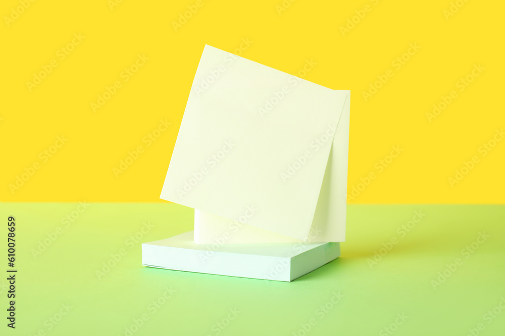 Sticky notes on green table near yellow wall